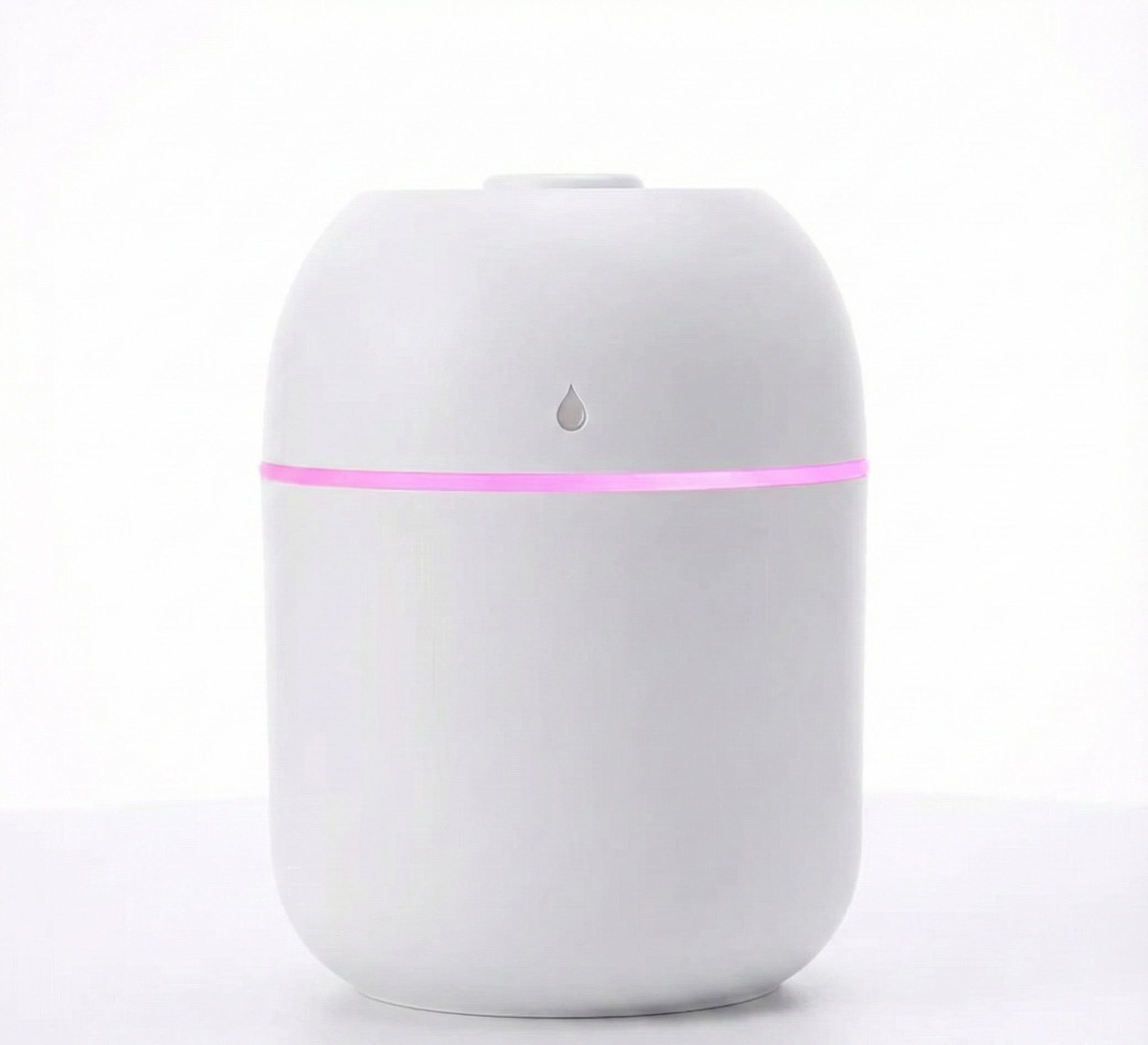 White essential oil diffuser with a pink light on a white background