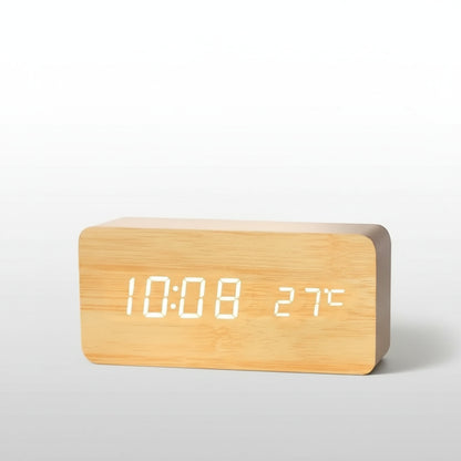 Wooden digital clock with white LED display on a wooden surface