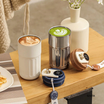Two coffee cups with different beverages on a wooden table, surrounded by additional coffee accessories.
