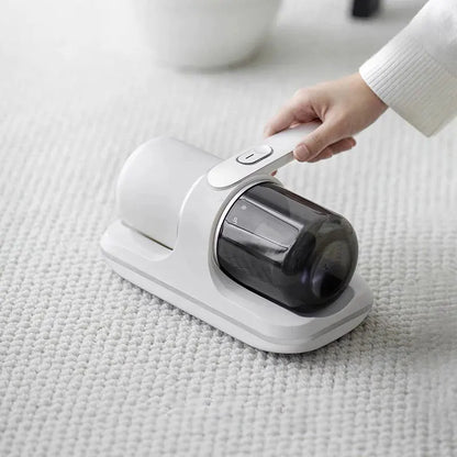 Hand using a handheld vacuum cleaner on a light-colored surface