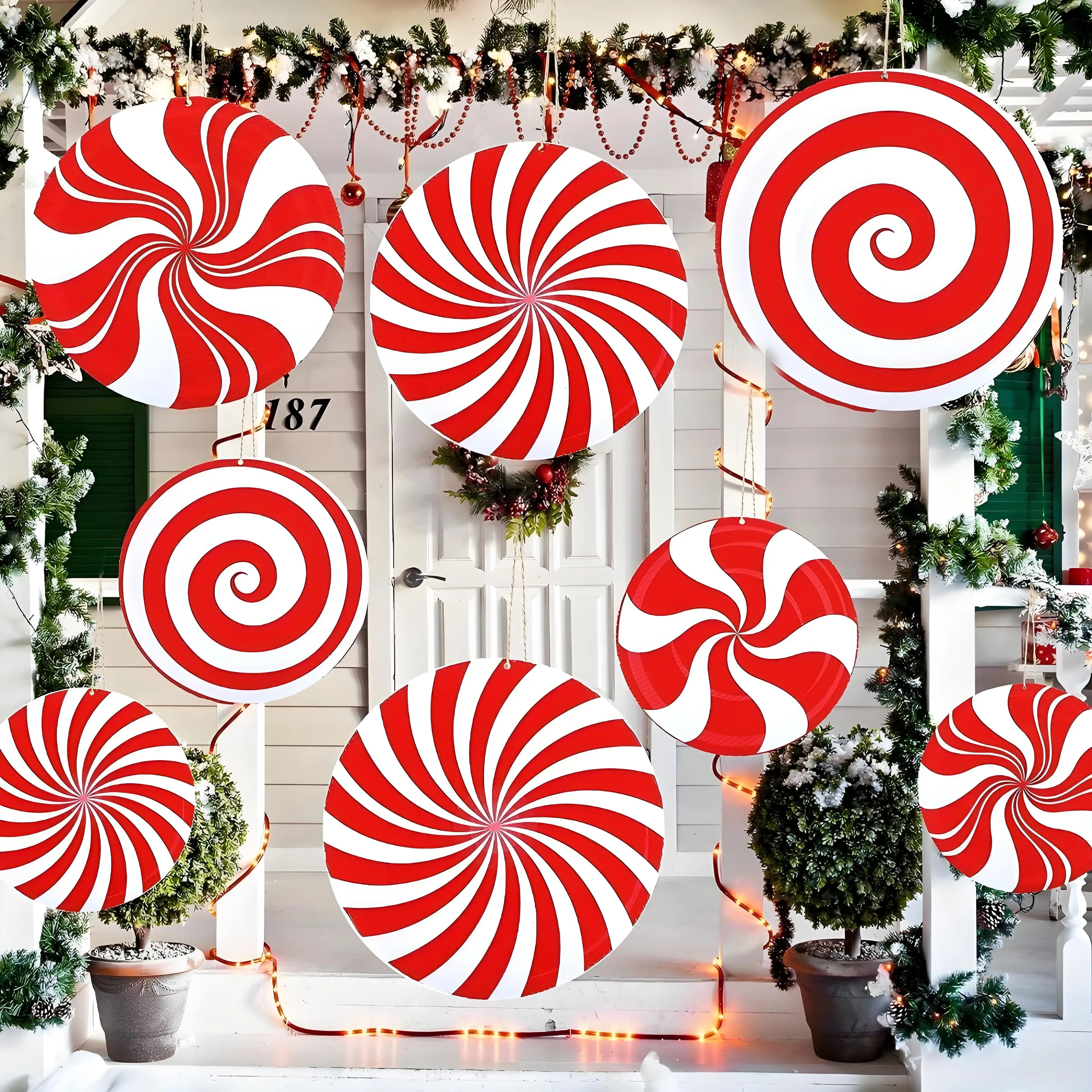 Red and white candy cane decorations on a door with Christmas trees and lights.